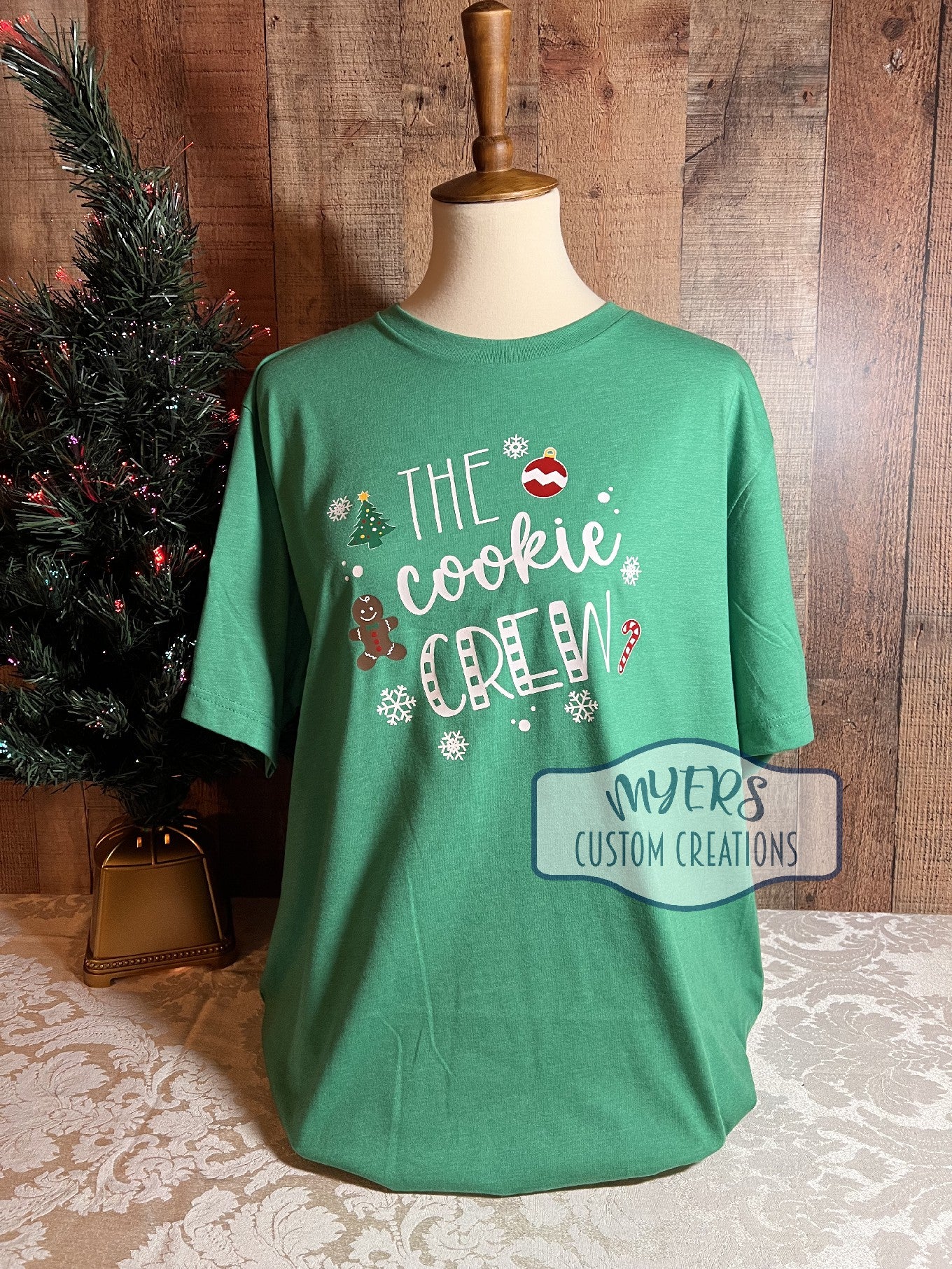 The Cookie Crew heather green Bella+Canvas t-shirt with white, red, green, chocolate, & yellow HTV