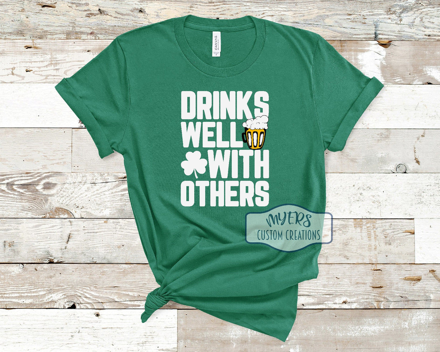 Drinks Well With Others kelly green Bella Canvas t-shirt with white, black, and sun HTV