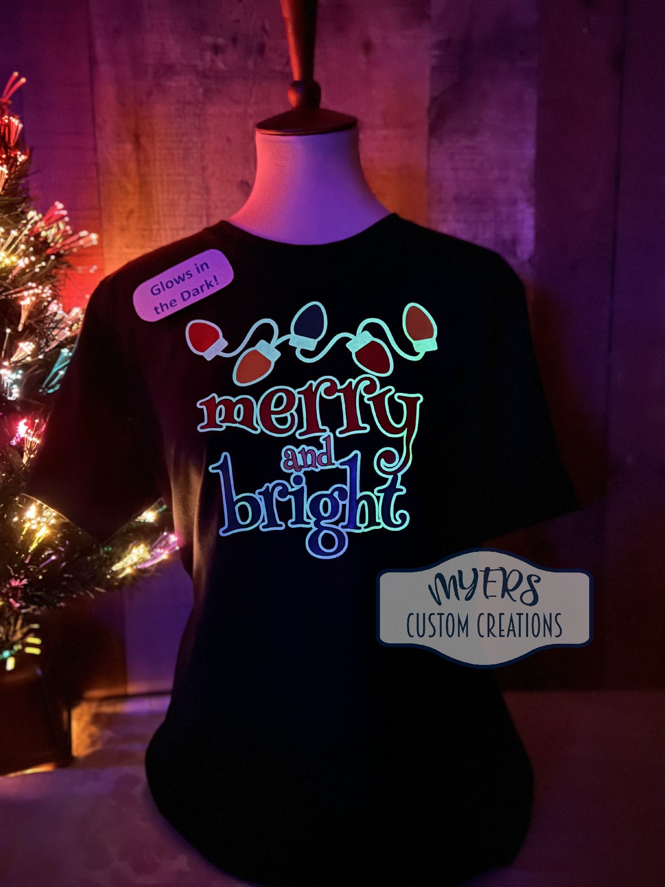 Merry and Brights Christmas Lights black t-shirt with glow in the dark white, red, green, & yellow HTV. Shown glowing in the dark.