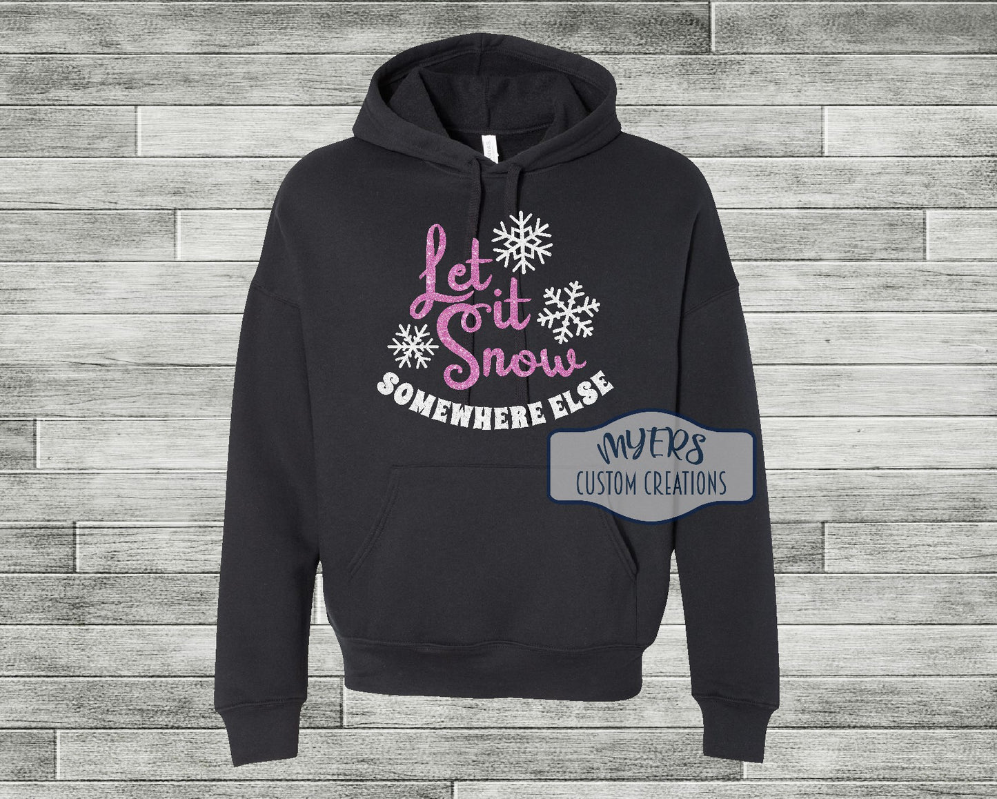 Let it Snow Somewhere Else on a black Bella Canvas hoodie with flamingo pink glitter and white glitter