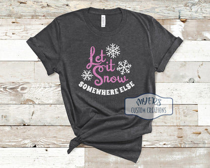 Let it Snow Somewhere Else on a heather dark grey t-shirt with flamingo pink glitter and white glitter