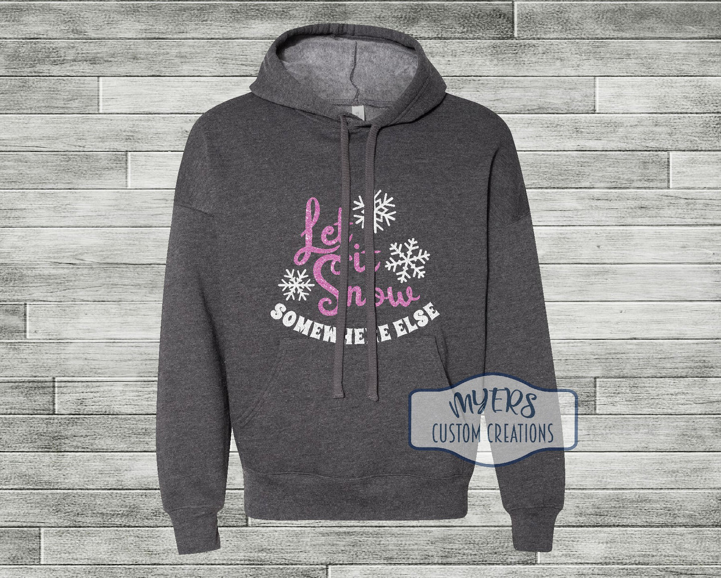 Let it Snow Somewhere Else on a heather dark grey Bella Canvas hoodie with flamingo pink glitter and white glitter